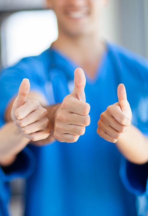 Three pediatric dental team members giving thumbs up